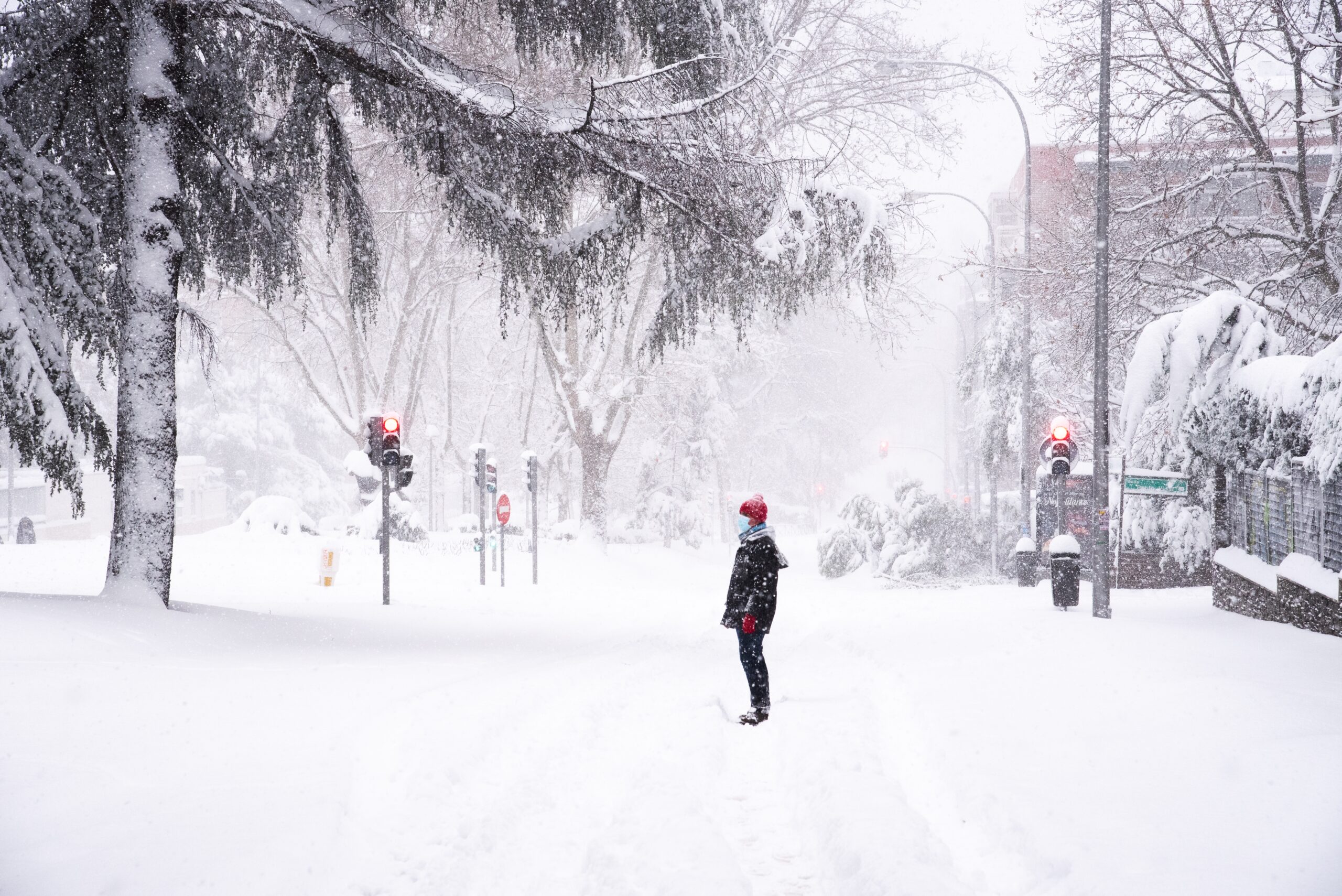 People walking on a city street during heavy snow storm. Climate change, extreme weather. Storm Filomena in Madrid. Arturo Soria area